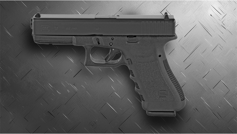 A black Glock 17 placed on a metallic surface, emphasizing its form against the smooth, reflective backdrop