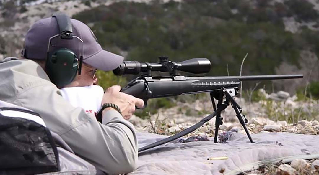 A professional shooter operating a black Ruger American Rifle